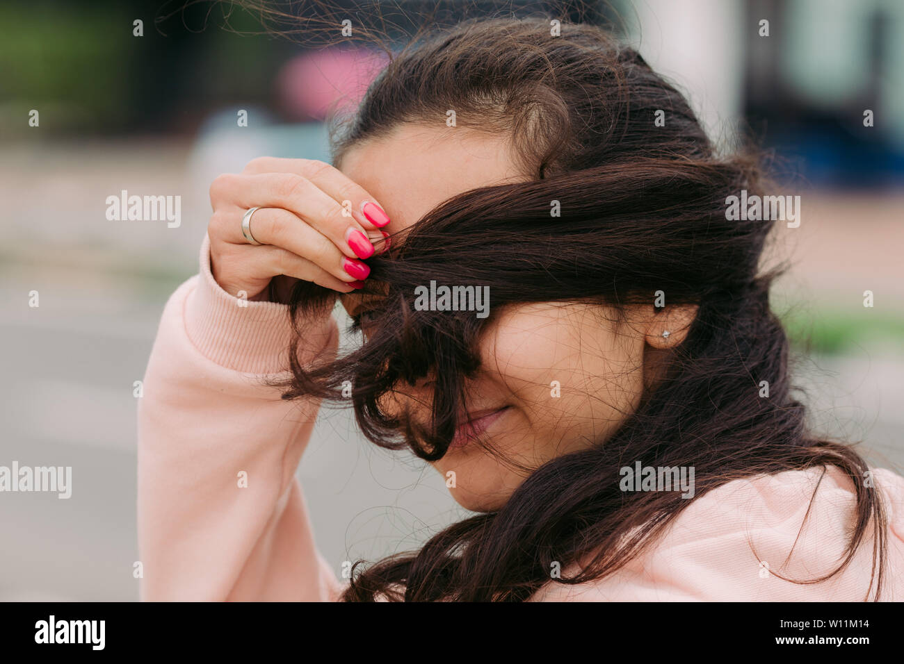 Chica cubre su cara con el cabello y travesuras Foto de stock