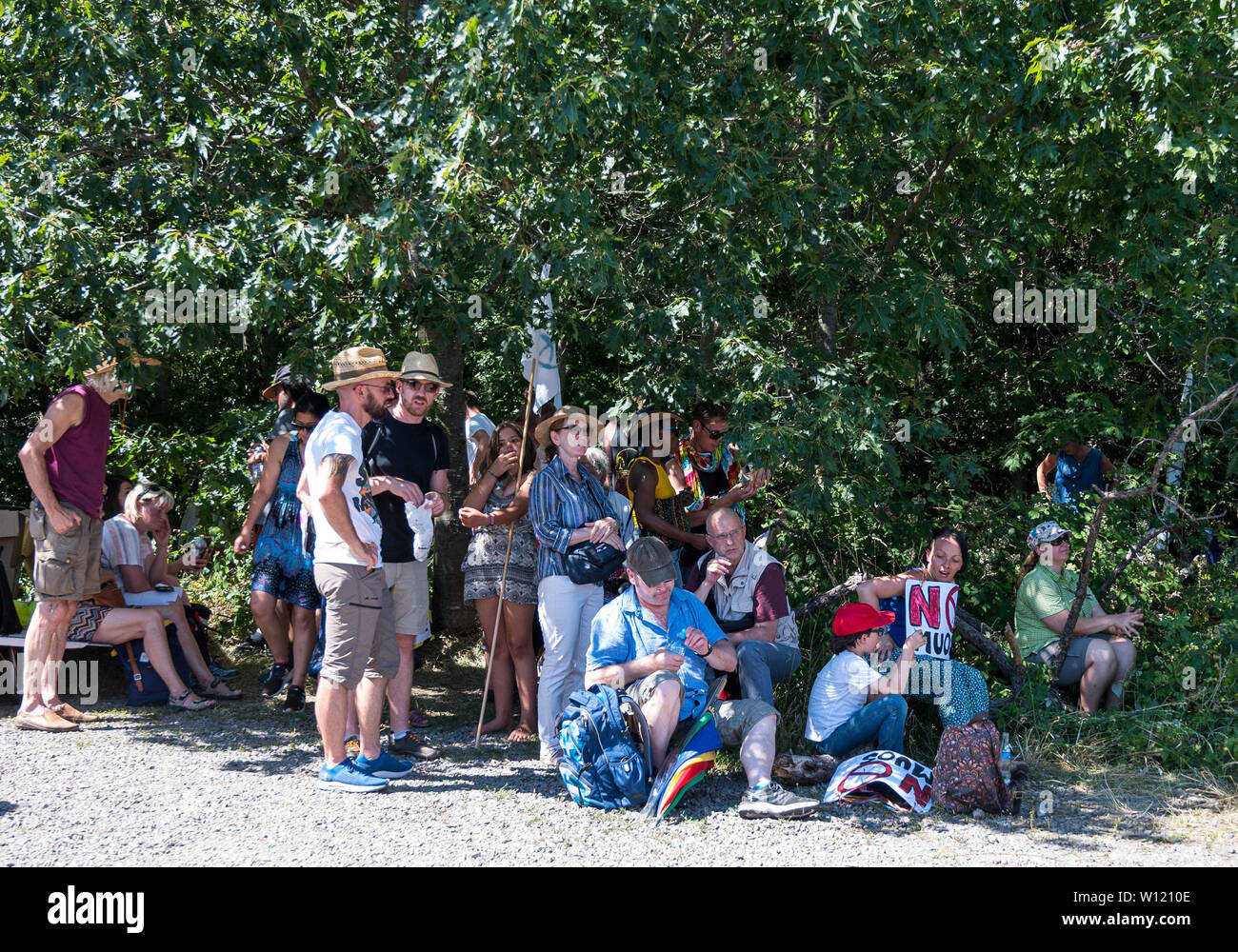 Miesenbach Ramstein, Alemania. El 29 de junio, 2019. Personas que se manifestaban contra la base aérea de Ramstein, buscan refugio del sol bajo los árboles. El movimiento de paz muestra contra la base militar, la cual es considerada como el centro de las operaciones militares de los estadounidenses. Crédito: Oliver Dietze/dpa/Alamy Live News Foto de stock