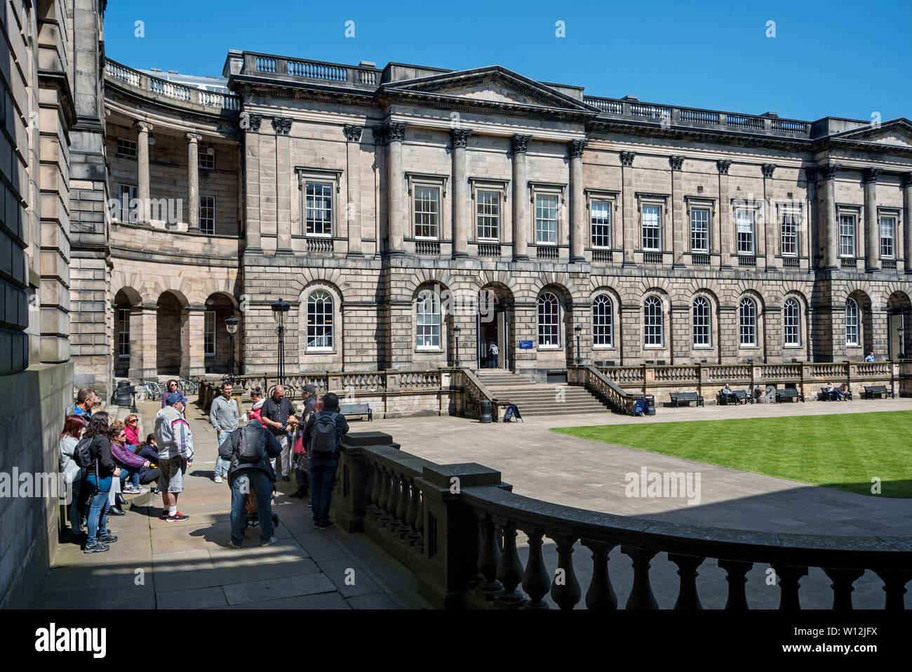 Los turistas visitan el Quad of Old College de la Universidad de Edimburgo, diseñado por Robert Adam y completado por William Henry Playfair en 1827. Foto de stock