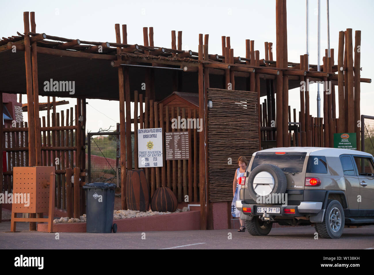Vehículo 4x4 y persona esperando a salir por la puerta del puerto de entrada Tweerivieren puesto de control fronterizo en el Parque Transfronterizo Kgalagadi, Sudáfrica Foto de stock