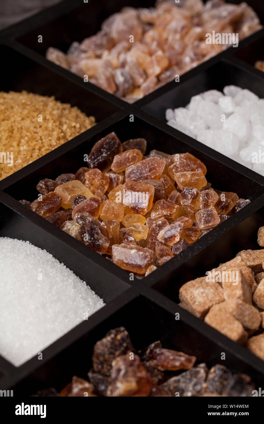 Diversos tipos de azúcar en una caja de madera. Blanco, marrón de caña de azúcar refinada colección Foto de stock