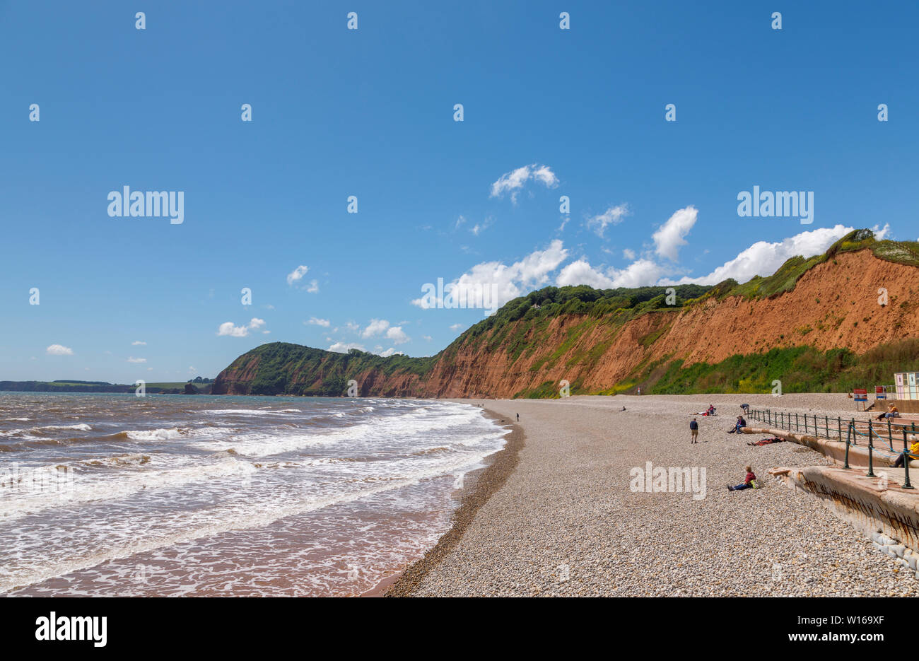 Vista a lo largo de la orilla de la playa de guijarros hacia alto pico mirando al occidente en Sidmouth, un agradable pueblo costero de la costa sur de Devon, en el suroeste de Inglaterra Foto de stock