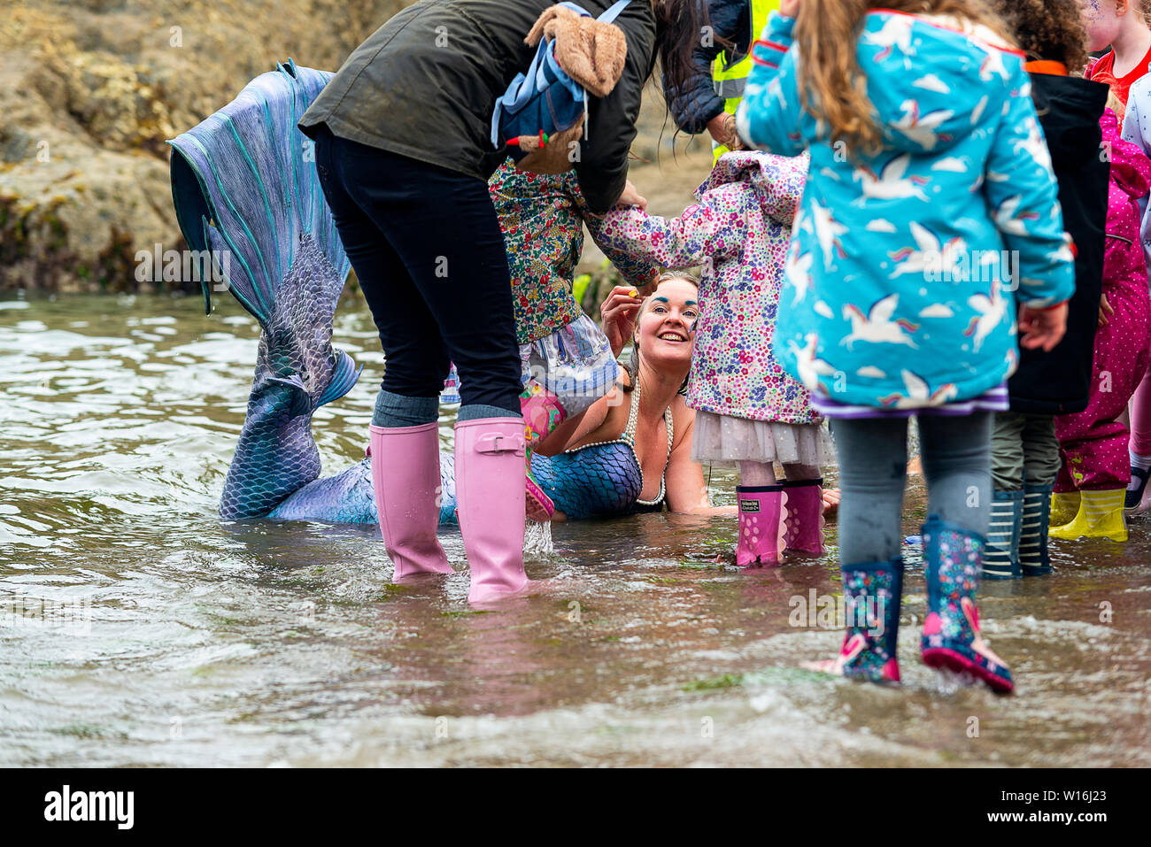 Editorial: Mevagissey, Cornualles, en el Reino Unido. 23/06/2019 Professional mermaid Laura Evans emociona a jóvenes y viejos como "lavados" en Mevagissey Harbour. Foto de stock