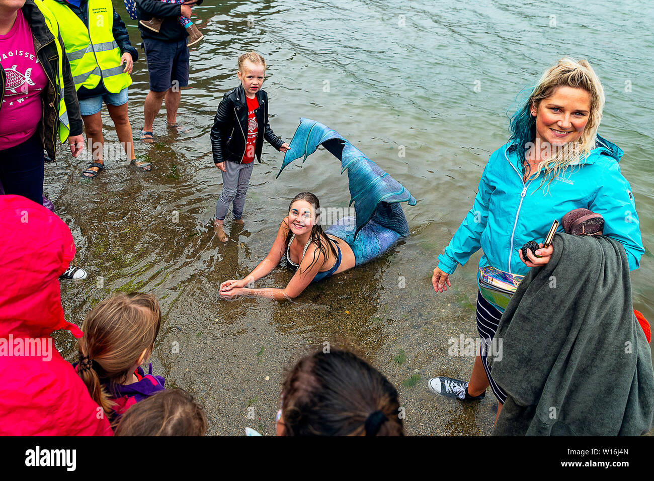 Editorial: Mevagissey, Cornualles, en el Reino Unido. 23/06/2019 Professional mermaid Laura Evans emociona a jóvenes y viejos como "lavados" en Mevagissey Harbour. Foto de stock