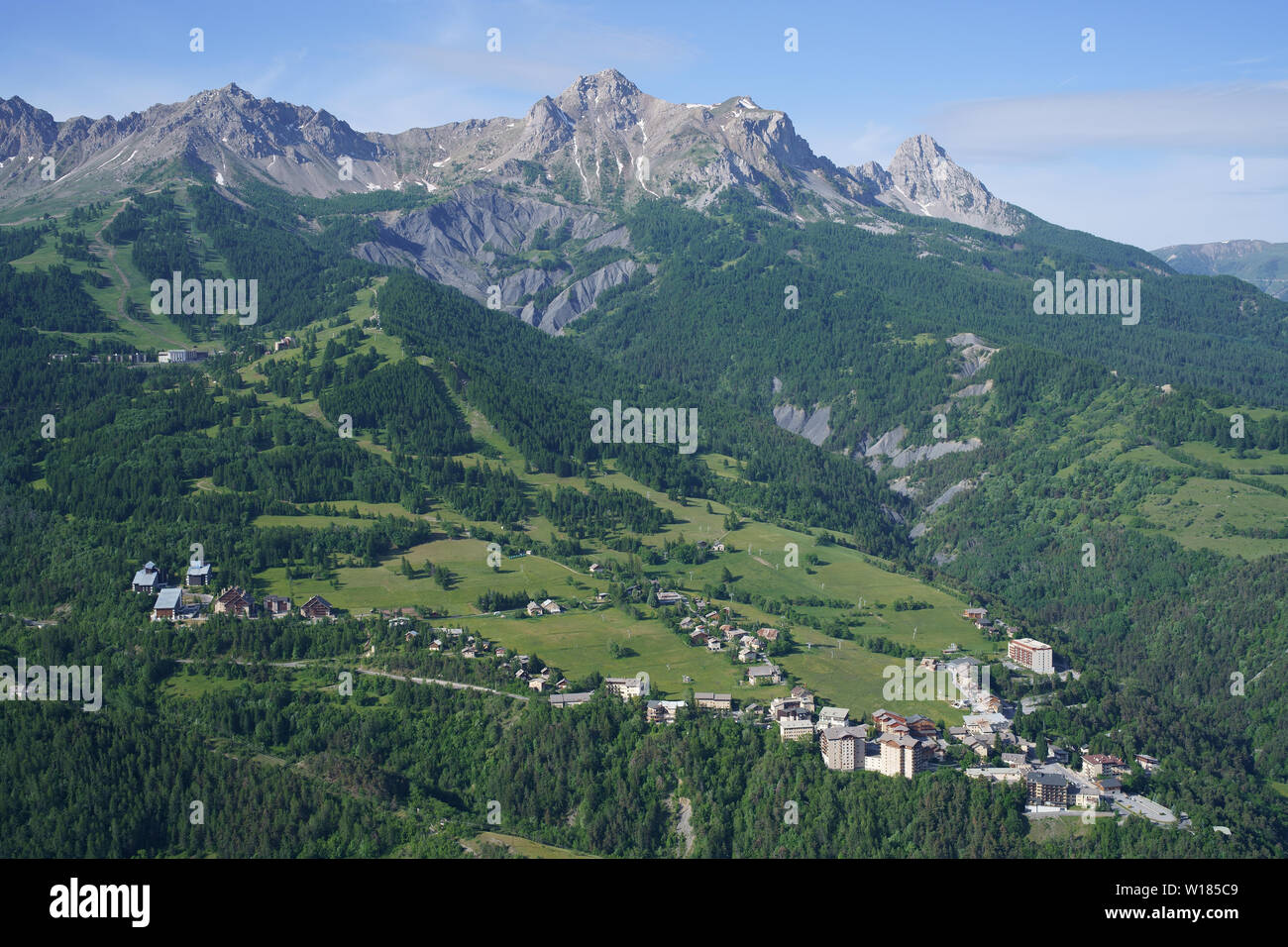 VISTA AÉREA. Estación de esquí de Le Sauze en verano, está dominada por el 'Chapeau du Gendarme' Peak (2682 metros). Enchastrayes, Valle de Ubaye, Francia. Foto de stock