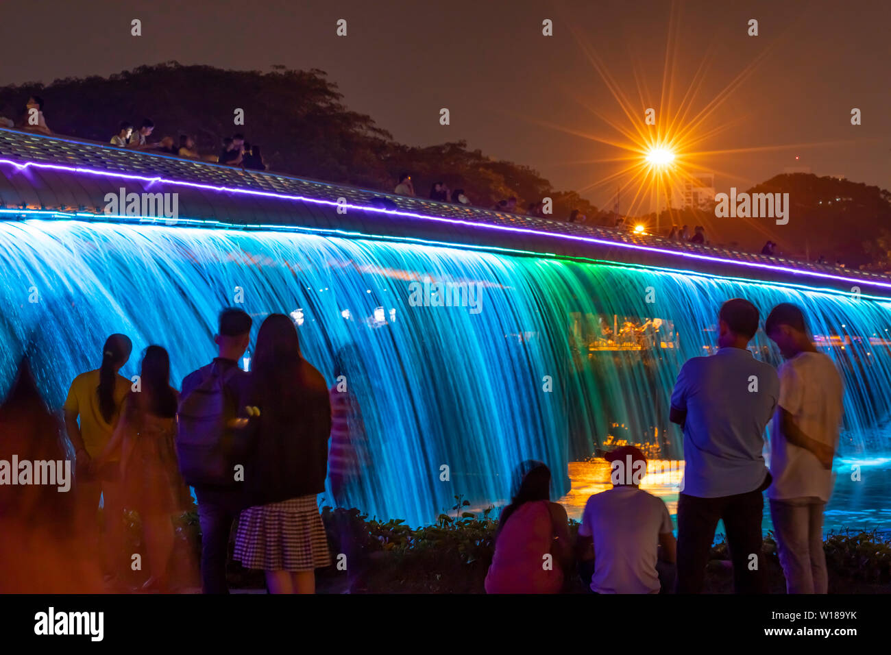 Personas disfrutando del Starlight Bridge o Puente en sao anh Hung Phu Mi distrito de la ciudad de Ho Chi Minh, Vietnam. Es una cascada iluminada solarpowered Foto de stock