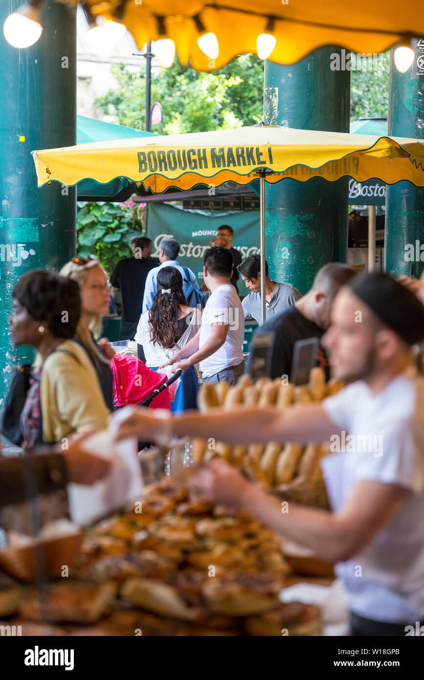 Una colorida y concurrida escena en el histórico mercado Borough Market en Southwark, Londres, famoso por su comida de todo el mundo Foto de stock