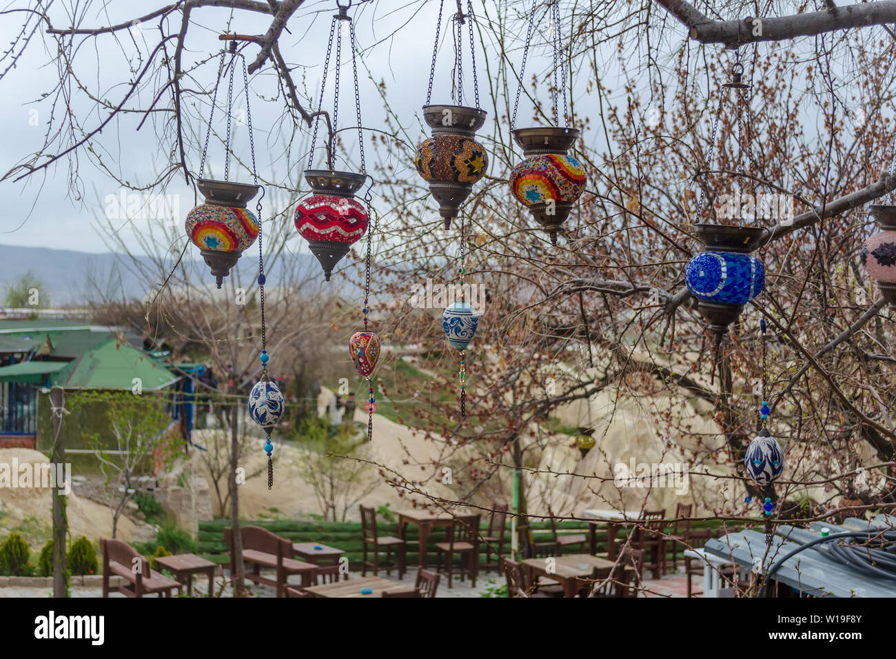 Artesanal de vidrio coloreado tradicional turco luces en las ramas de un árbol cerca. A comienzos de la primavera, la preparación para la temporada turística de Capadocia. Foto de stock