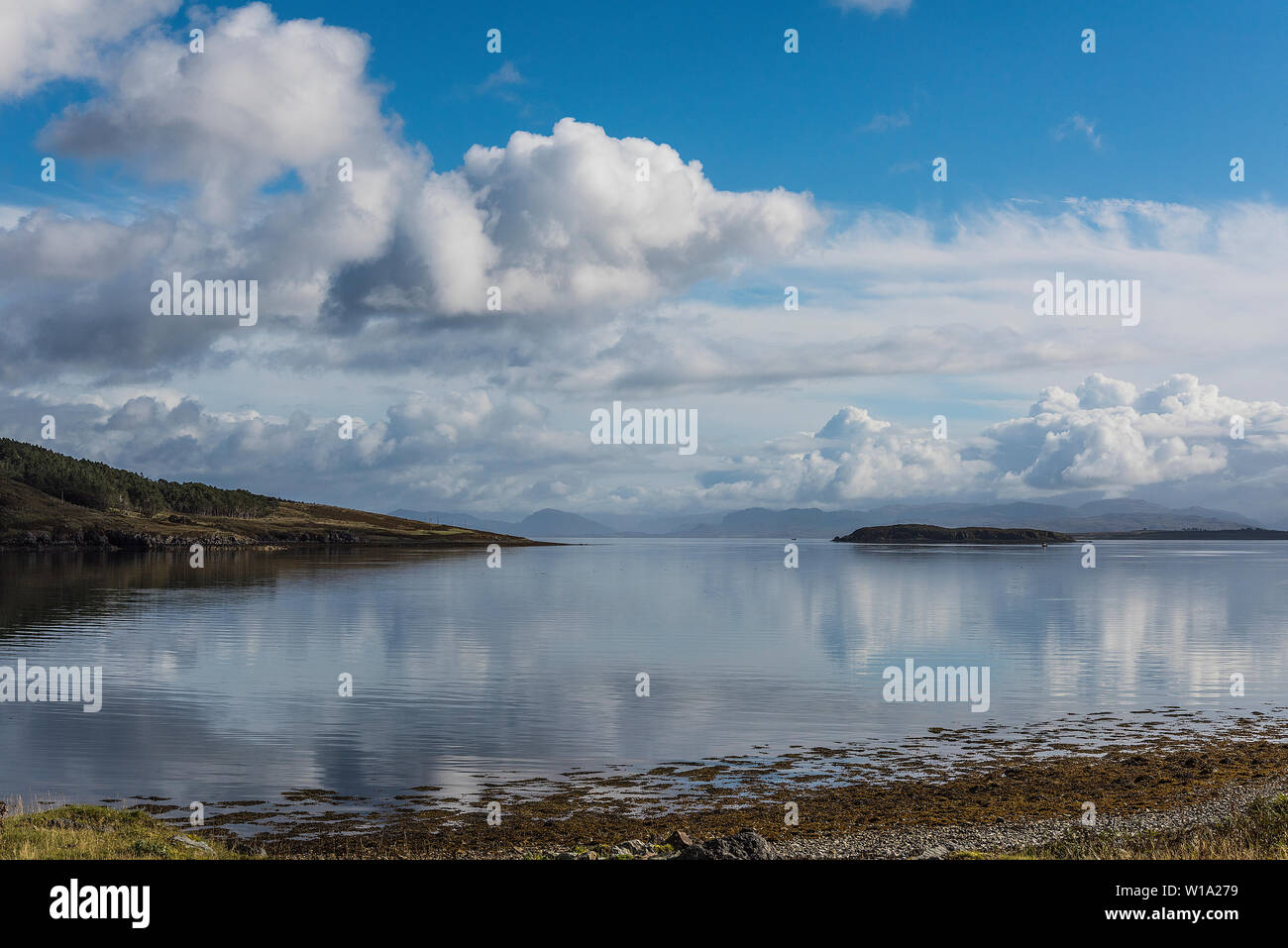 Isla de Skye Loch con refleja el cielo azul y las nubes Foto de stock