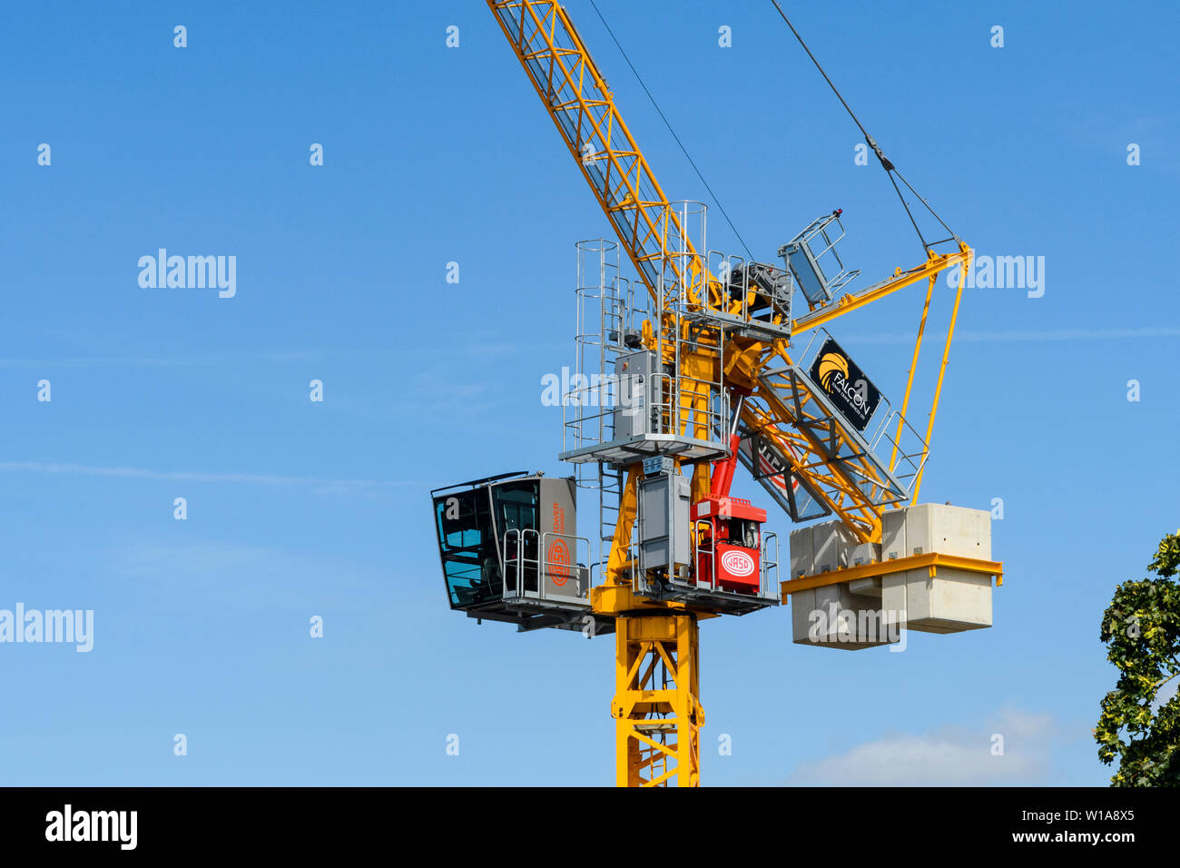 Tall amarillo grúa torre de elevación y trabajando en la construcción sitio contra el cielo azul profundo (cabina, mástil, pluma y pesos), York, North Yorkshire, Inglaterra, Reino Unido. Foto de stock