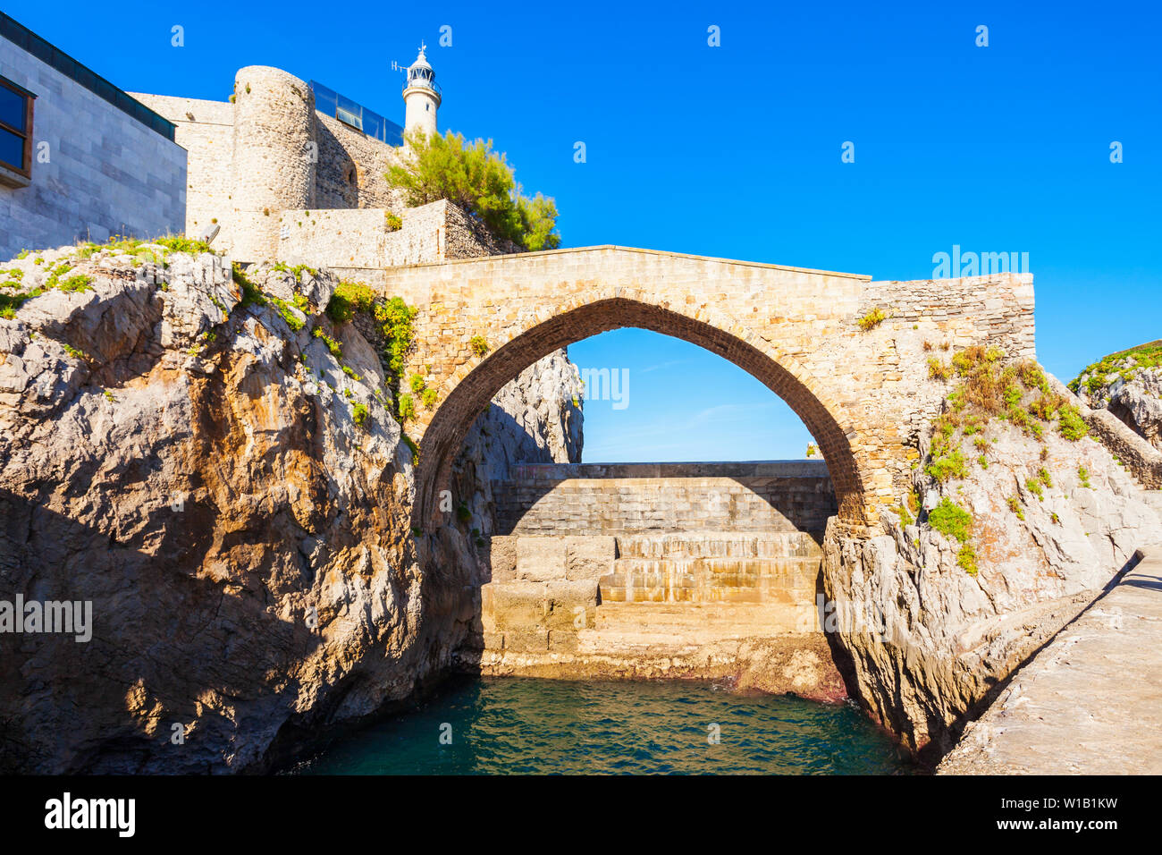 Castillo de Santa Ana puente y faro de Castro Urdiales, pequeña ciudad de la región de Cantabria, en el norte de España Foto de stock