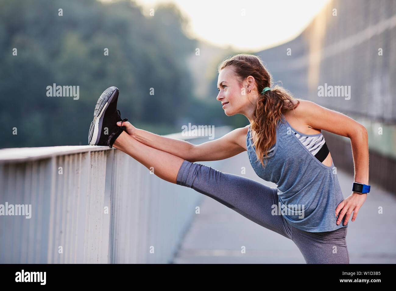 Atleta Femenina estirar las piernas después de ejecutar Foto de stock