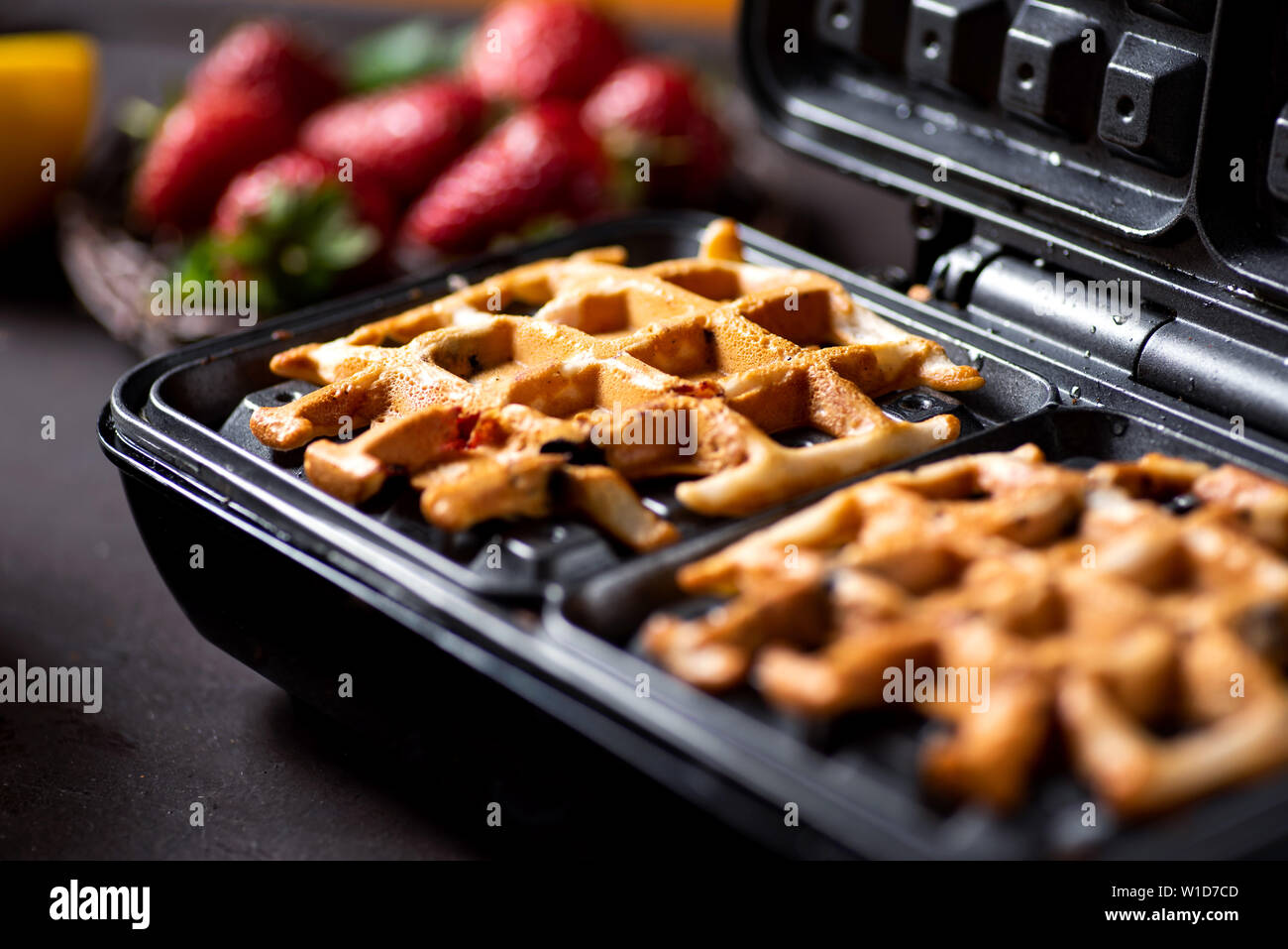 Waffle hornear pasteles en una máquina de hacer gofres máquina cerrar Foto de stock