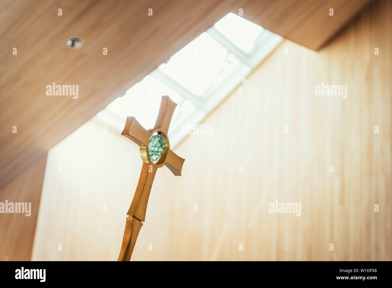 Hermoso crucifijo de metal dorado en la iglesia, la incidencia de la luz en el fondo Foto de stock