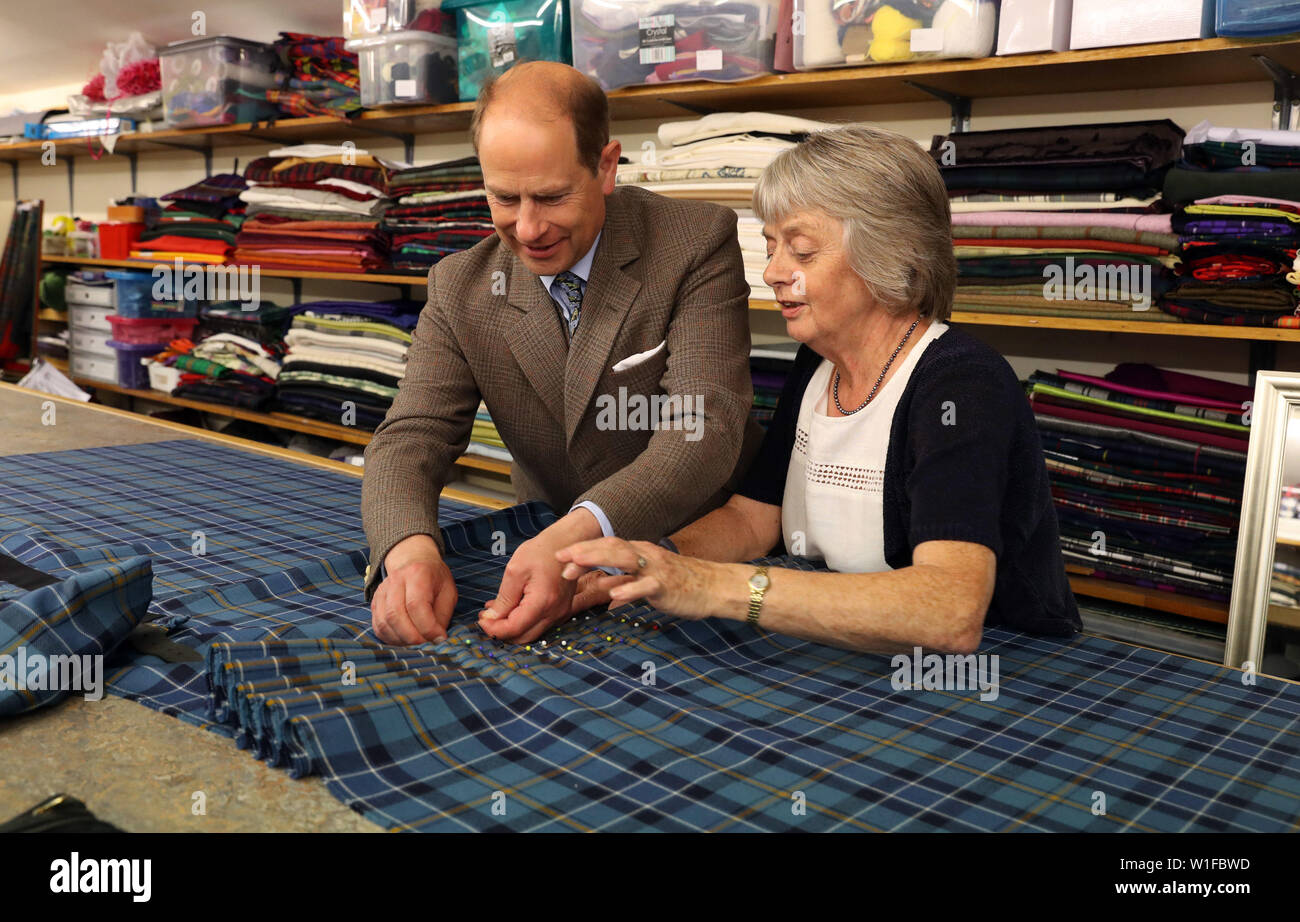 El conde de Forfar Folding encima un pliegue en Banff y Buchan tartan falda vigilados por Norna Sutherland, durante una visita a la escuela de Keith falda y centro textil en Keith. Foto de stock