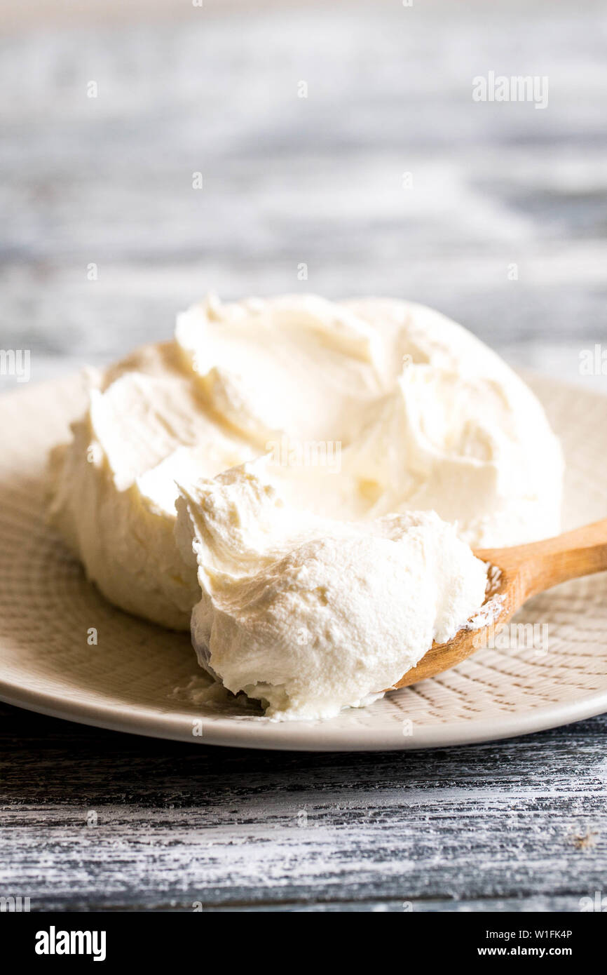 Fresco mascarpone casero. Queso Mascarpone tradicional en una cuchara de  madera Fotografía de stock - Alamy