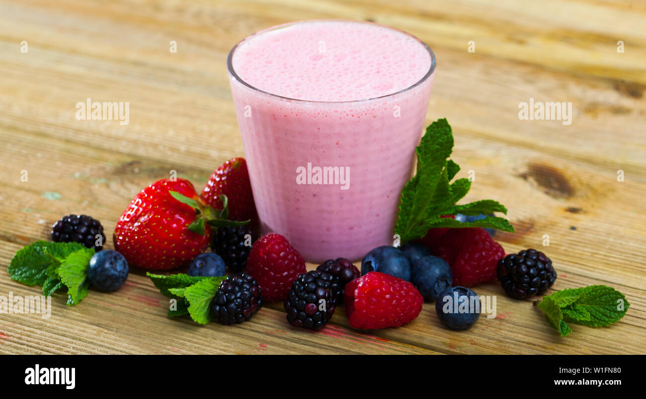Batido con yogur y bayas de fondo con arándanos frescos, frambuesas, fresas,  moras y menta Fotografía de stock - Alamy