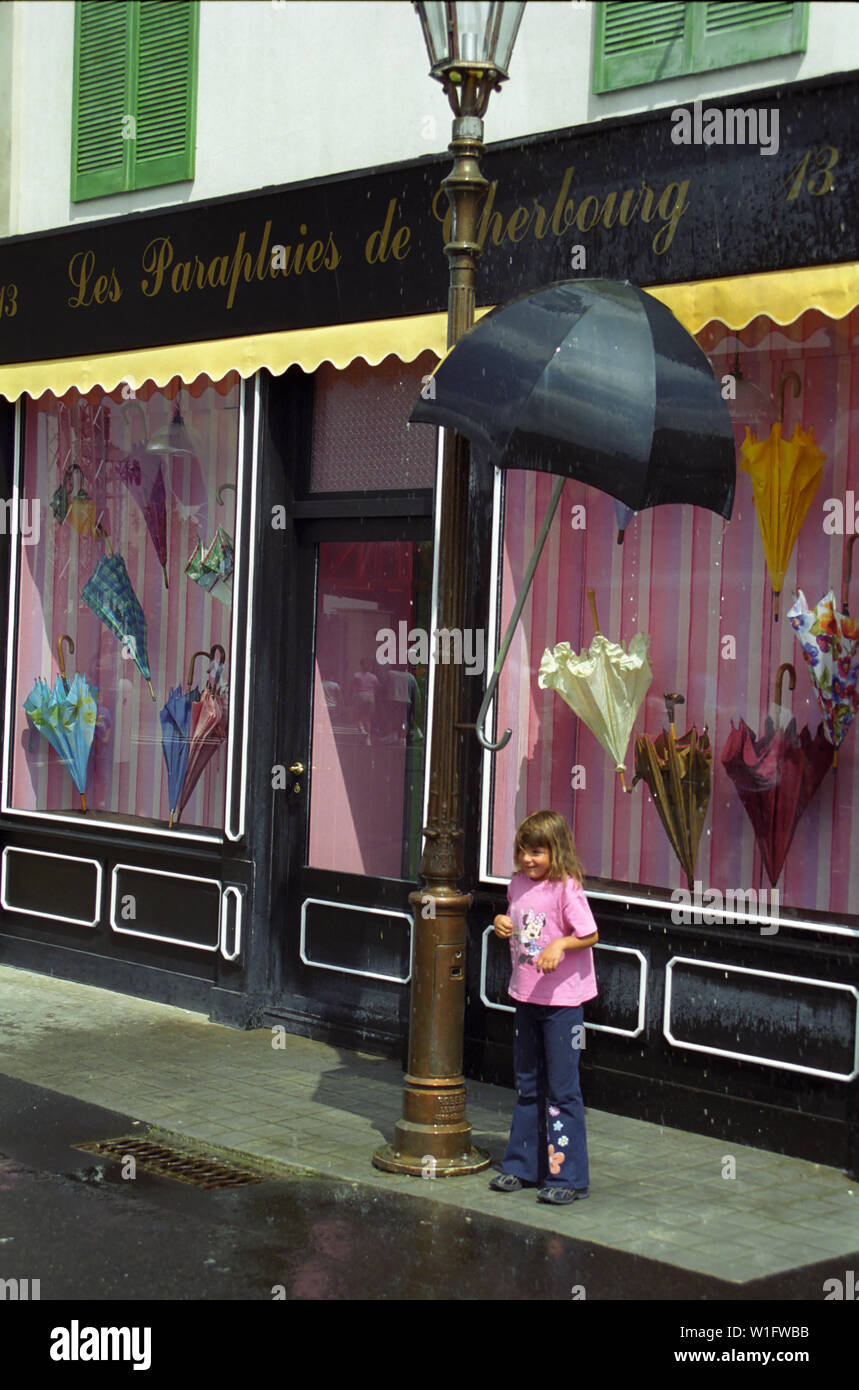 guapo cable cómodo El niño está bajo un paraguas para protegerse de la lluvia falsa: Les  Parapluies de Cherbourg, Walt Disney Studios Park, Paris, Francia  Fotografía de stock - Alamy