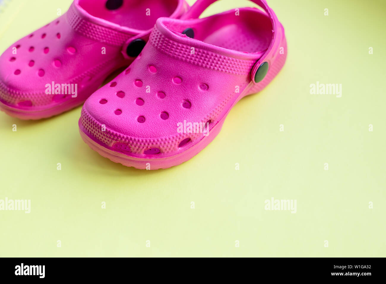 San Diego, Estados Unidos, 10 de mayo de 2019.El verano rosa flip flops  aislado sobre fondo amarillo. niños sandalias de goma blanda o Crocs.vacaciones  de verano zapatos de moda Fotografía de stock -