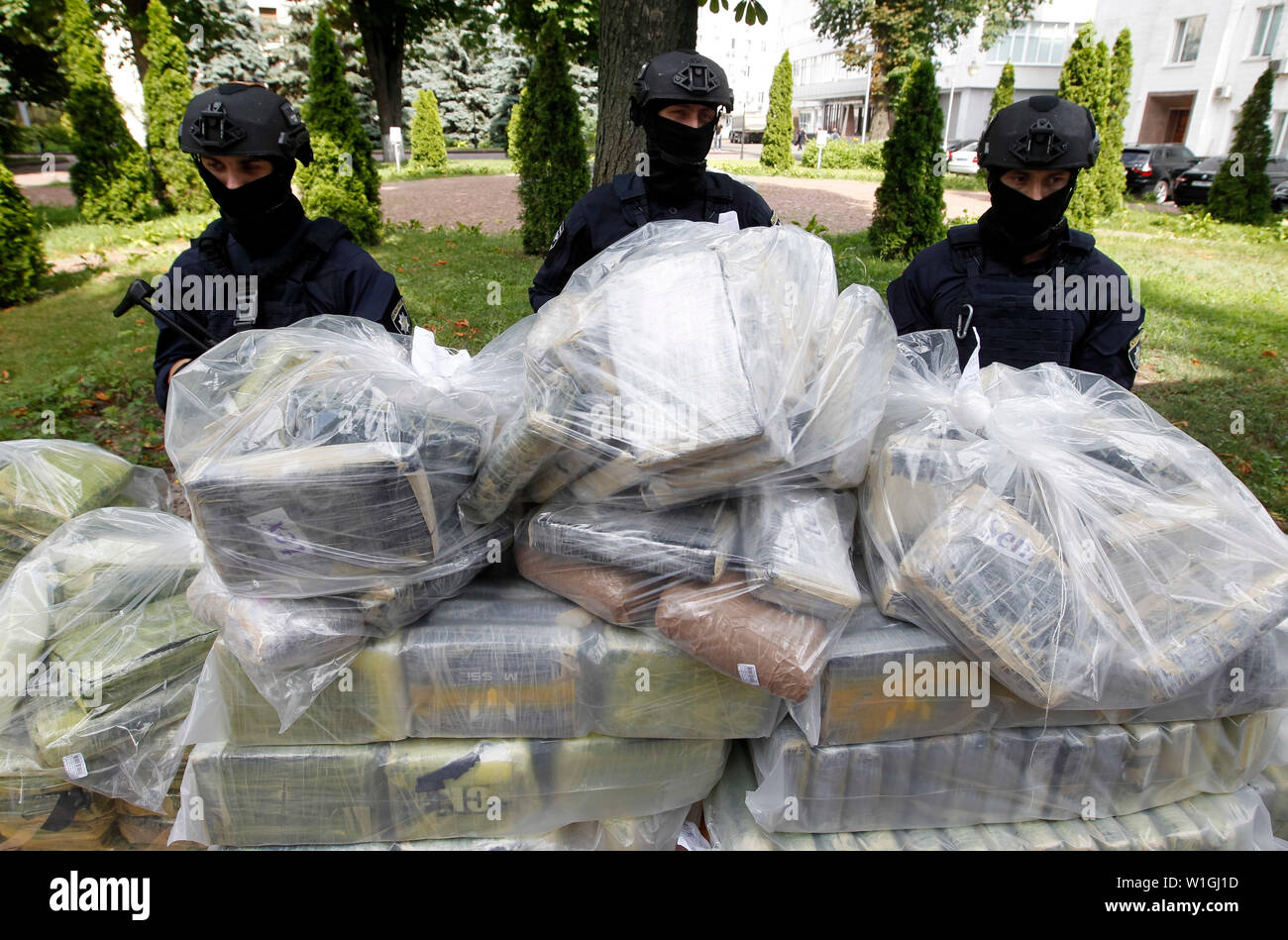Soporte de agentes de policía de guardia junto a las bolsas de cocaína, que fueron incautados durante una operación policial especial en una conferencia de prensa de la Policía Nacional y el Departamento de Policía Antinarcóticos y el Departamento de la Drug Enforcement Administration (DEA) en el Ministerio de Asuntos Internos en Kiev.La policía de Ucrania, en cooperación con la DEA estadounidense reveló el canal transnacional de drogas de Colombia a la UE y detuvo a los traficantes de drogas y se incautó de 400 kg de cocaína coste estimado de 60 millones de dólares, que iban a ser transferidas desde América Latina a través de Ucrania a Foto de stock