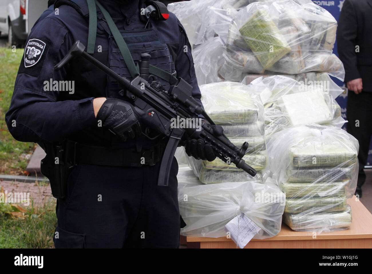 Soporte de agentes de policía de guardia junto a las bolsas de cocaína, que fueron incautados durante una operación policial especial en una conferencia de prensa de la Policía Nacional y el Departamento de Policía Antinarcóticos y el Departamento de la Drug Enforcement Administration (DEA) en el Ministerio de Asuntos Internos en Kiev.La policía de Ucrania, en cooperación con la DEA estadounidense reveló el canal transnacional de drogas de Colombia a la UE y detuvo a los traficantes de drogas y se incautó de 400 kg de cocaína coste estimado de 60 millones de dólares, que iban a ser transferidas desde América Latina a través de Ucrania a Foto de stock