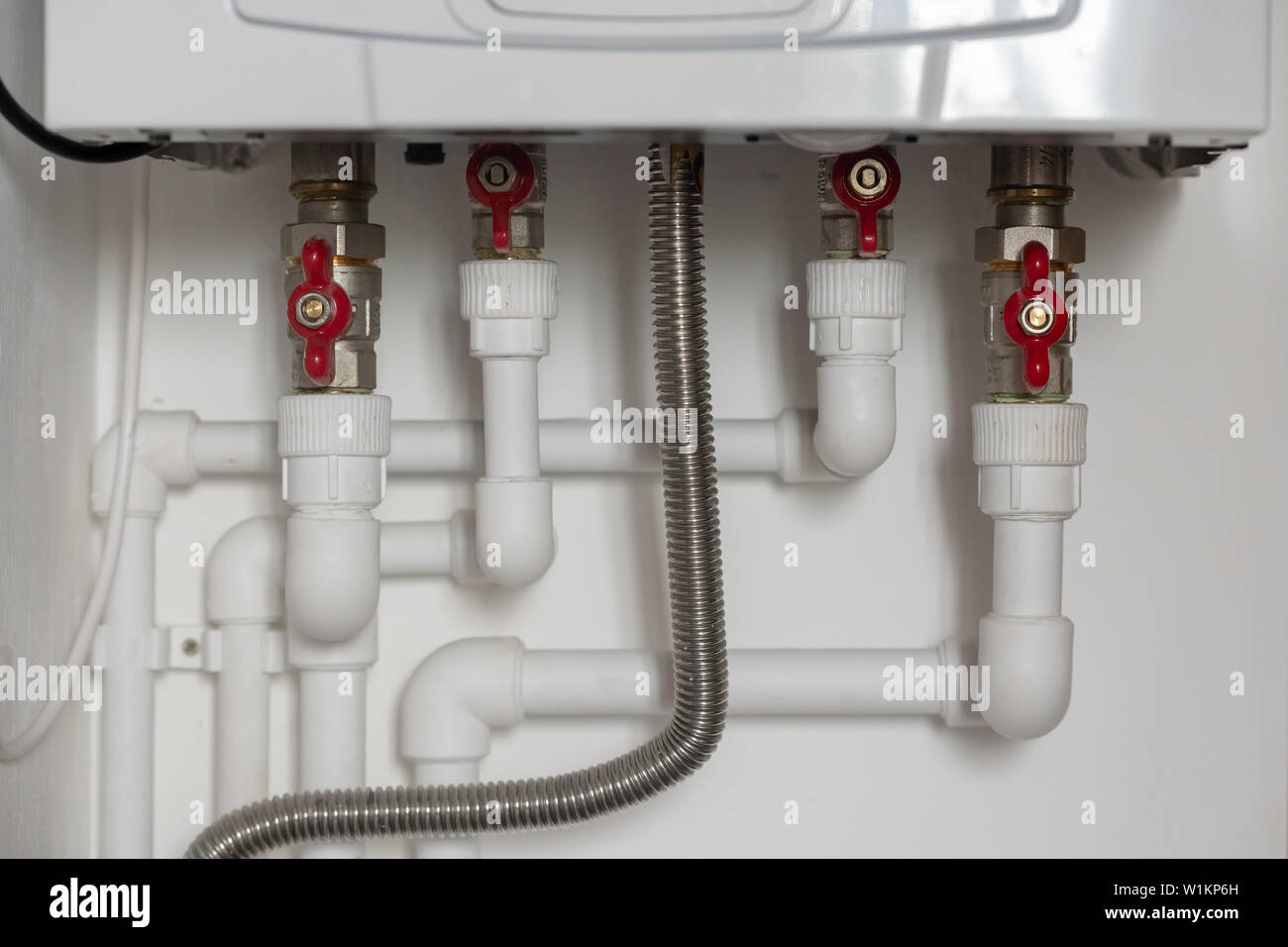 Descripción: conexiones de tuberías de plástico para el calentador de agua en el apartamento Foto de stock
