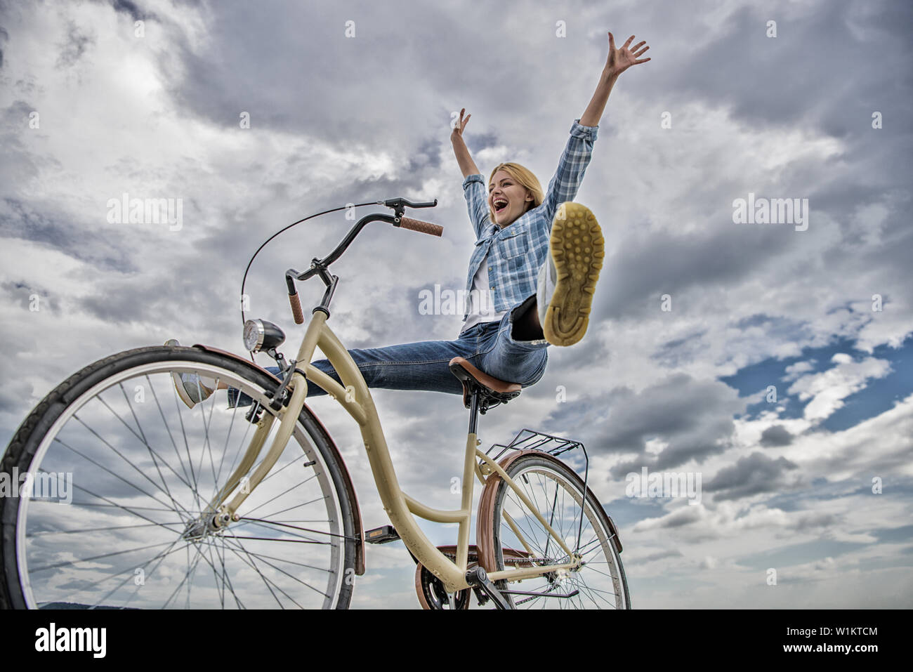La mujer se siente feliz mientras disfruta de ciclismo. Paseos en bicicleta  chica de fondo del cielo. Cómo ciclismo cambia tu vida y te hacen feliz.  Razones para andar en bicicleta. Los