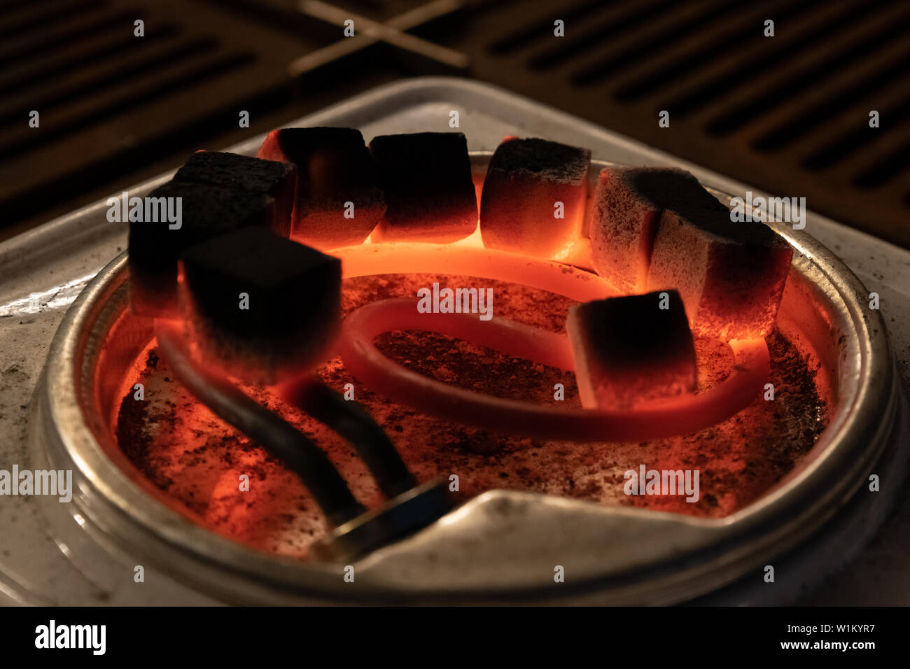 Descripción: carbón para narguile de calor en una estufa eléctrica Foto de stock