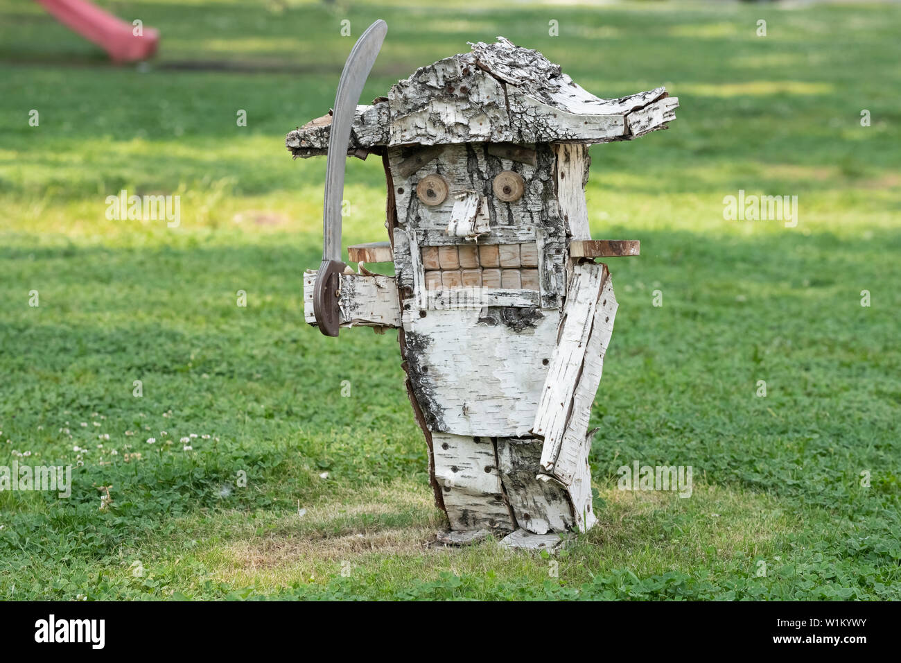 Descripción: una escultura en madera del cascanueces de birch artesanal sobre un fondo de hierba Foto de stock