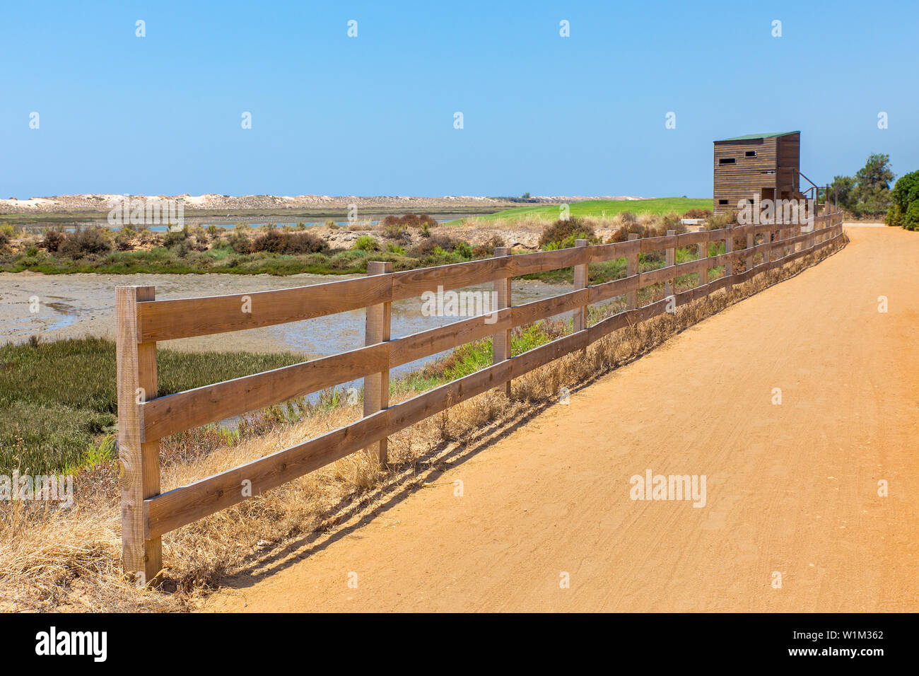 Zona costera portuguesa con el sendero de arena, valla de madera y cabaña Foto de stock