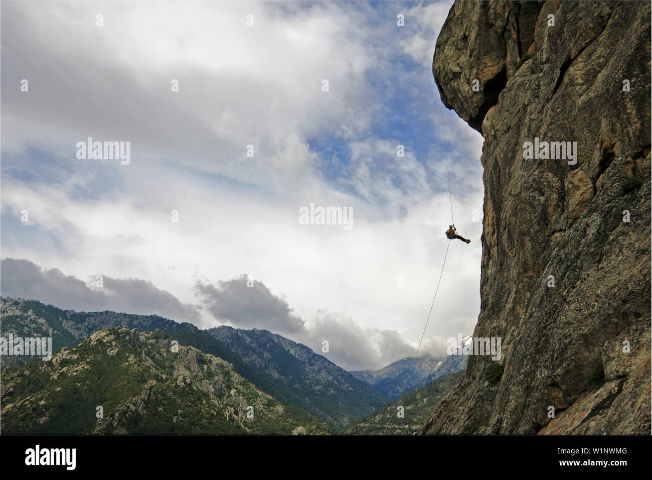 Hombre en un rockcliff abseils cerca de Pont du Vecchio, Mediterráneo, Córcega, Francia Foto de stock