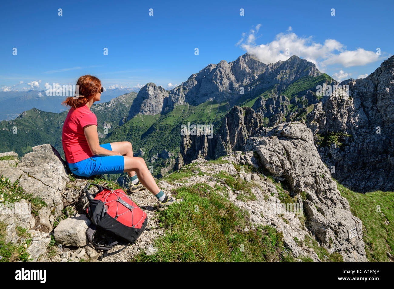 Mujer mirando hacia Grignone senderismo, desde Grignetta, Grigna, Bergamasque Alpes, Lombardía, Italia Foto de stock