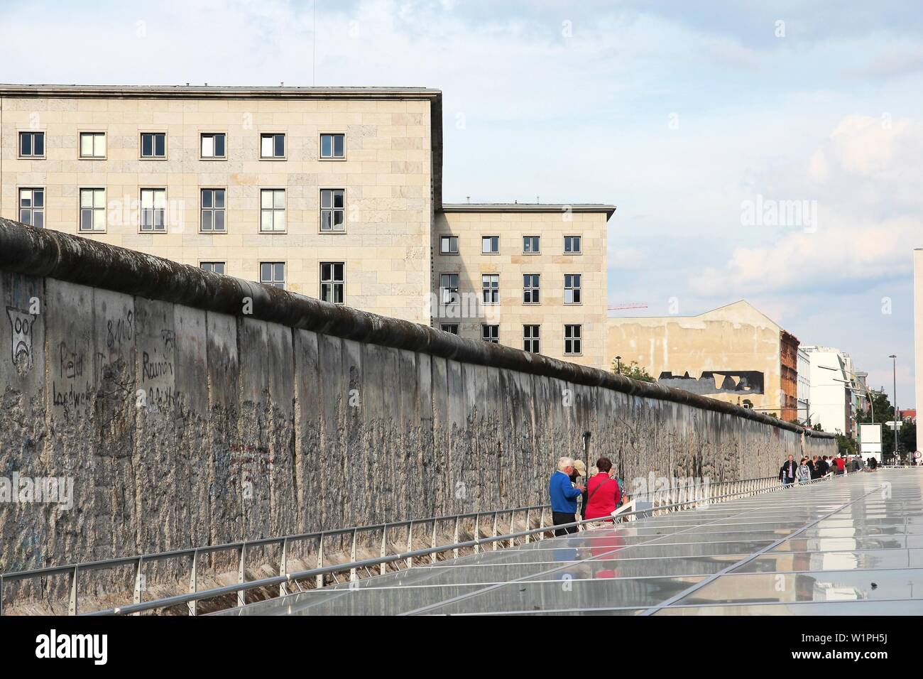 BERLIN, ALEMANIA - Agosto 26, 2014: la gente visite la histórica muralla de Berlín. El muro de Berlín fue una barrera histórica que existía desde 1961 hasta 1989. Foto de stock