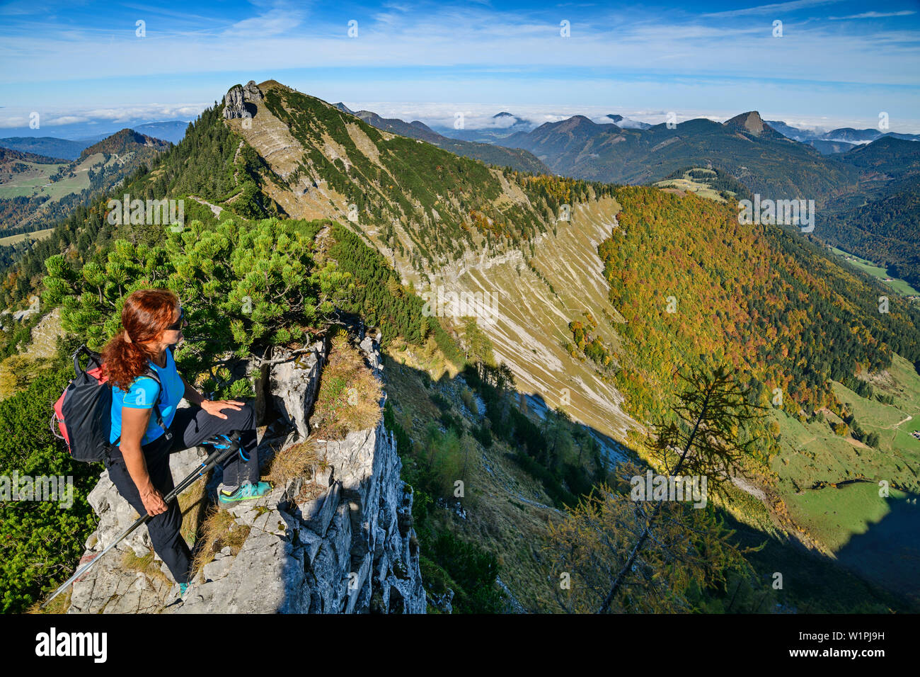 Senderismo mujer mirando por encima del acantilado, en el fondo, Regenspitz desde Gruberhorn, Salzkammergut, Salzburgo, Austria Foto de stock