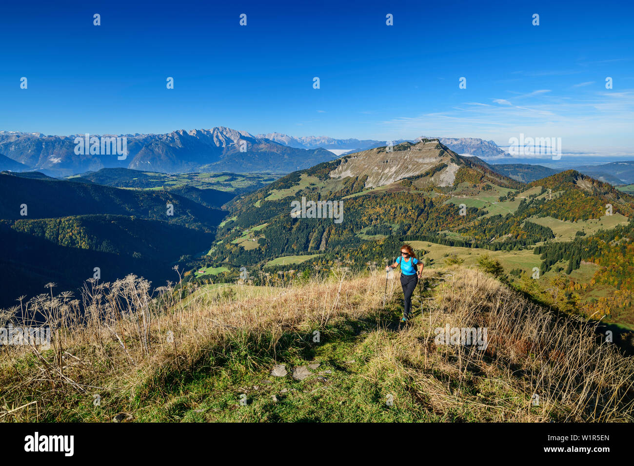 Mujer caminata ascendiendo hacia Regenspitz, Alpes Berchtesgaden y Schmittenstein en fondo, desde Regenspitz, Salzkammergut, Salzburgo, Austria Foto de stock