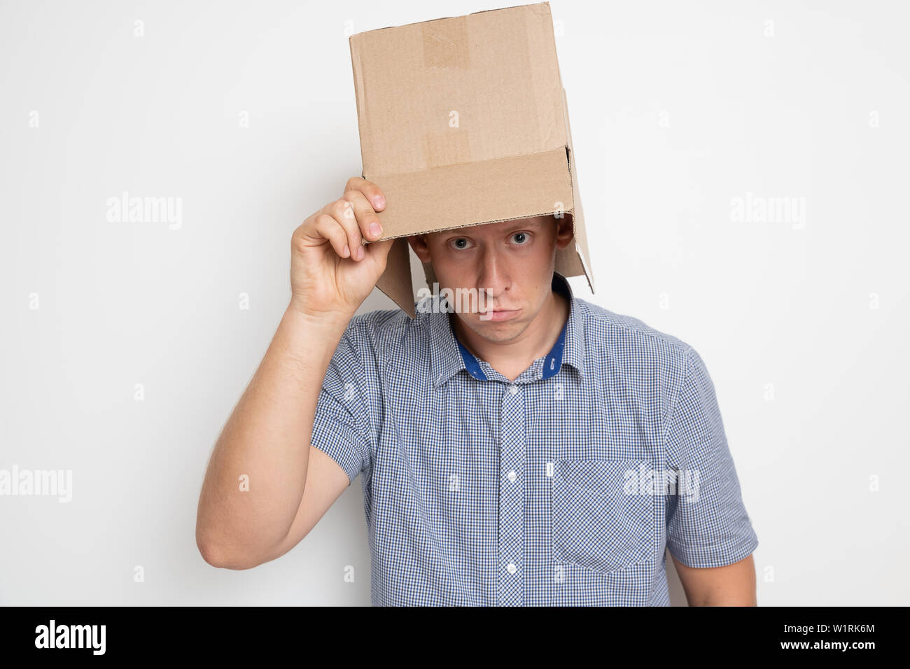 Descripción: el hombre se pone un saco sobre su cabeza. Foto de stock