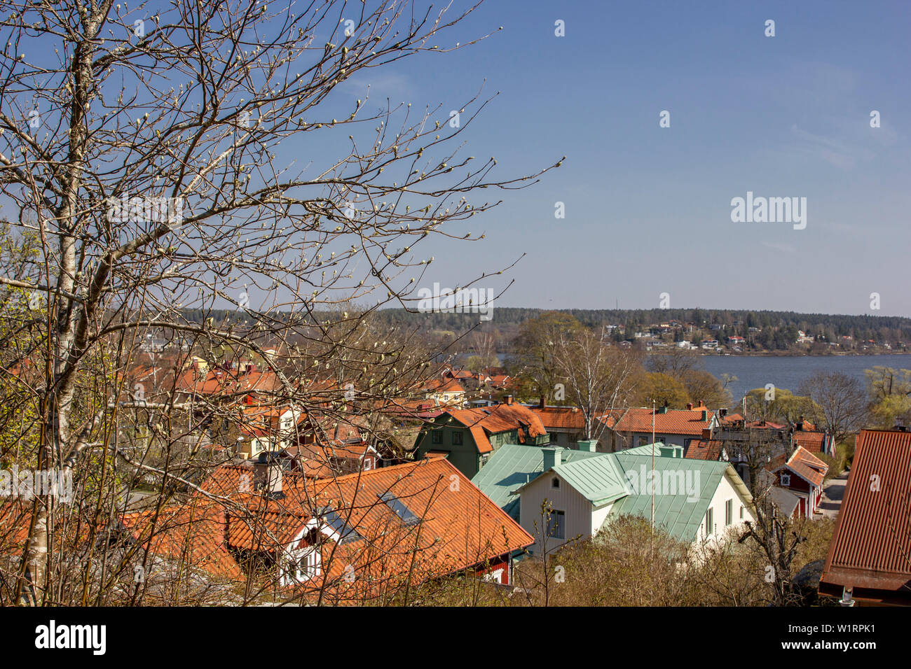 Residencias de teja roja rodean a las orillas del lago Mälaren en el antiguo pueblo de Sigtuna, Suecia en una fría mañana de Abril. Foto de stock