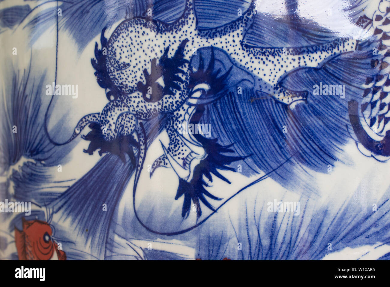 China o asiática artística representación de azul y blanco y un dragón koi fish en un satinado o brillante superficie cerámica de una urna o jarrón cerrar Foto de stock