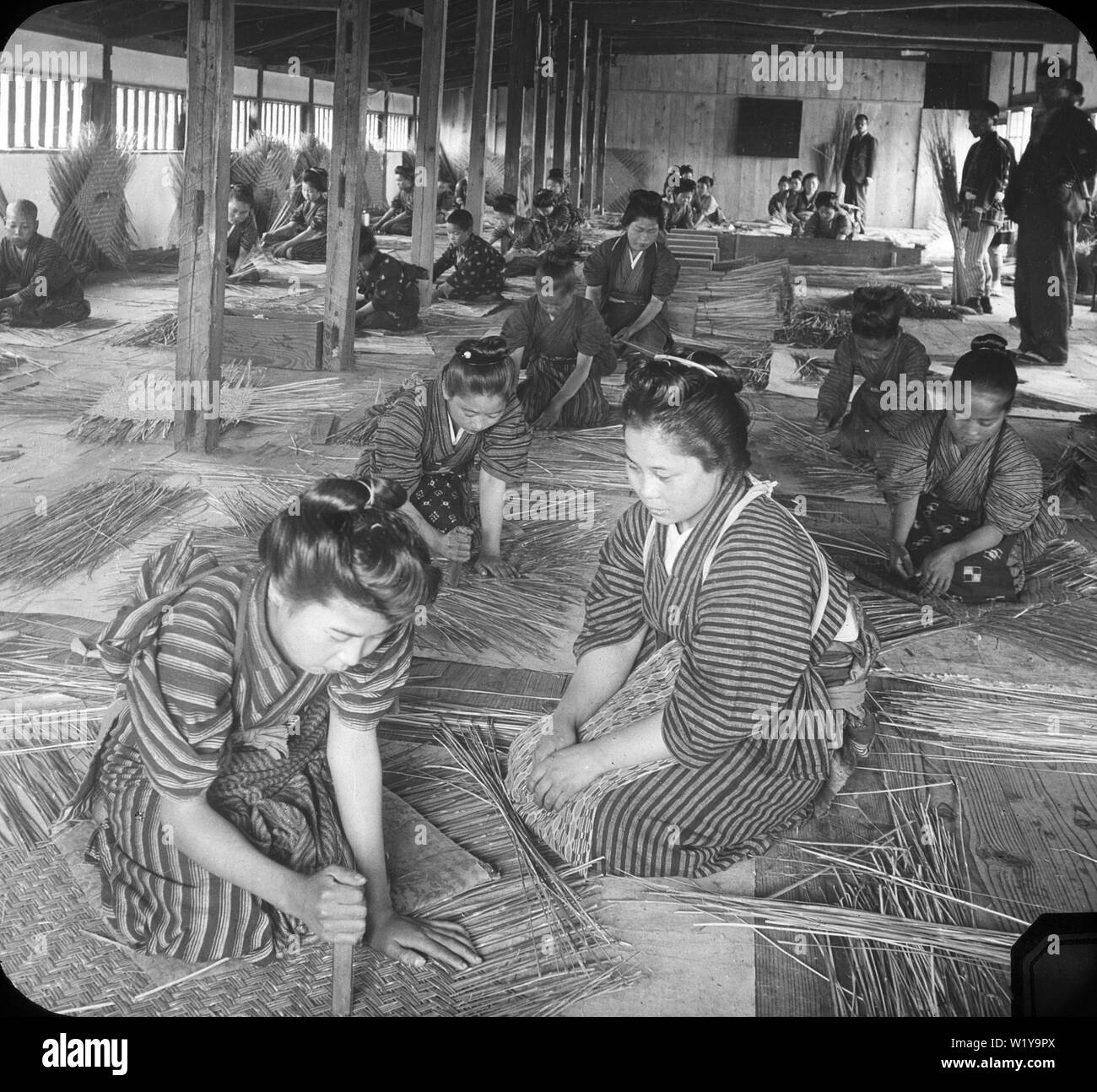[ 1900 Japón - Las mujeres y las niñas que trabajan en la fábrica de cesta de bambú ] - jóvenes y mujeres en el trabajo en una fábrica de cesta de bambú, 1904. Vintage del siglo 20 portaobjetos de vidrio. Foto de stock