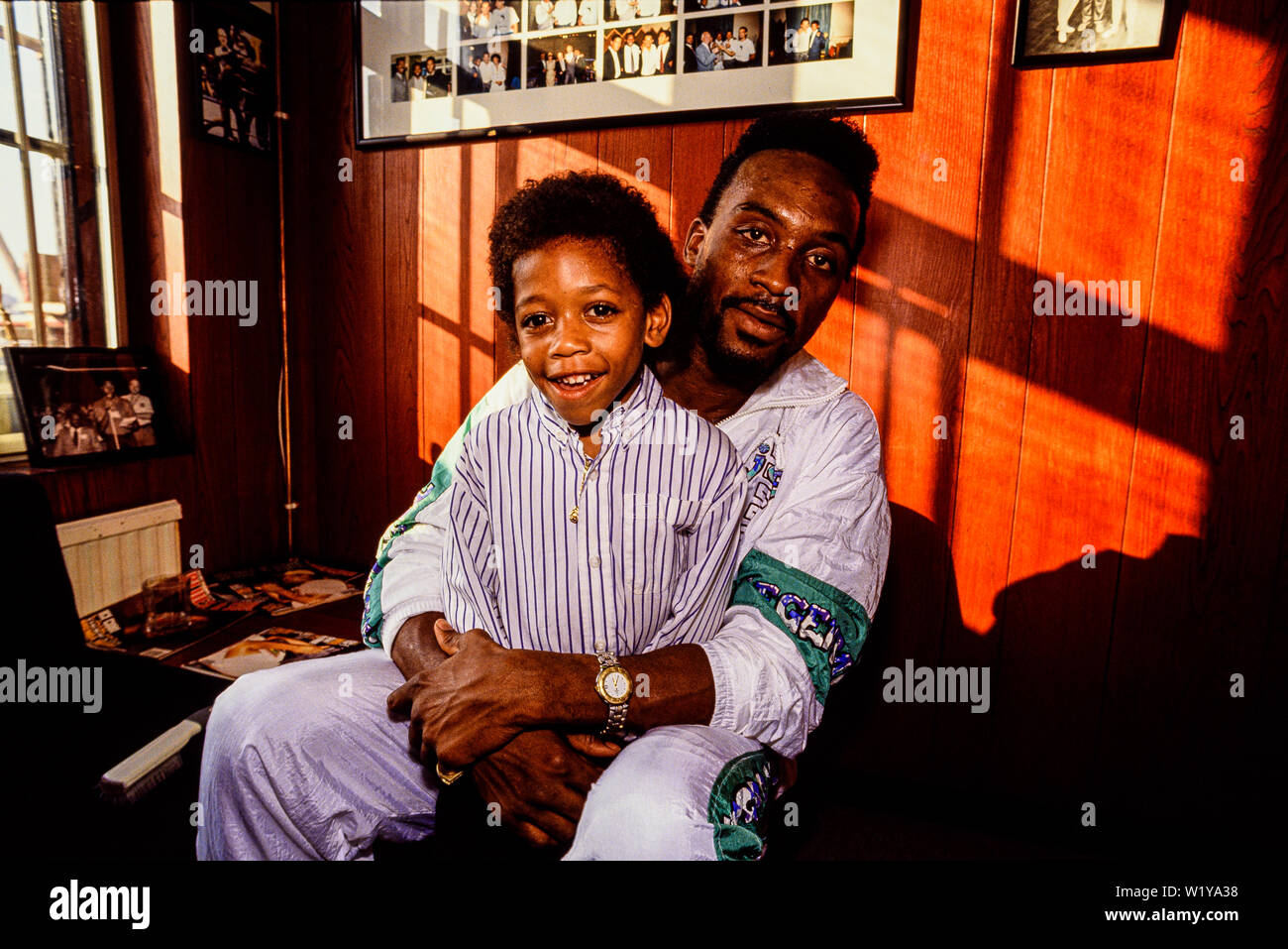 Londres, 1990. Retrato de boxeador Nigel Benn con su hijo Domingo. Apodado el destructor Oscuro, ocupó la WBO de peso medio en 1990 y el título de la WBC Foto de stock