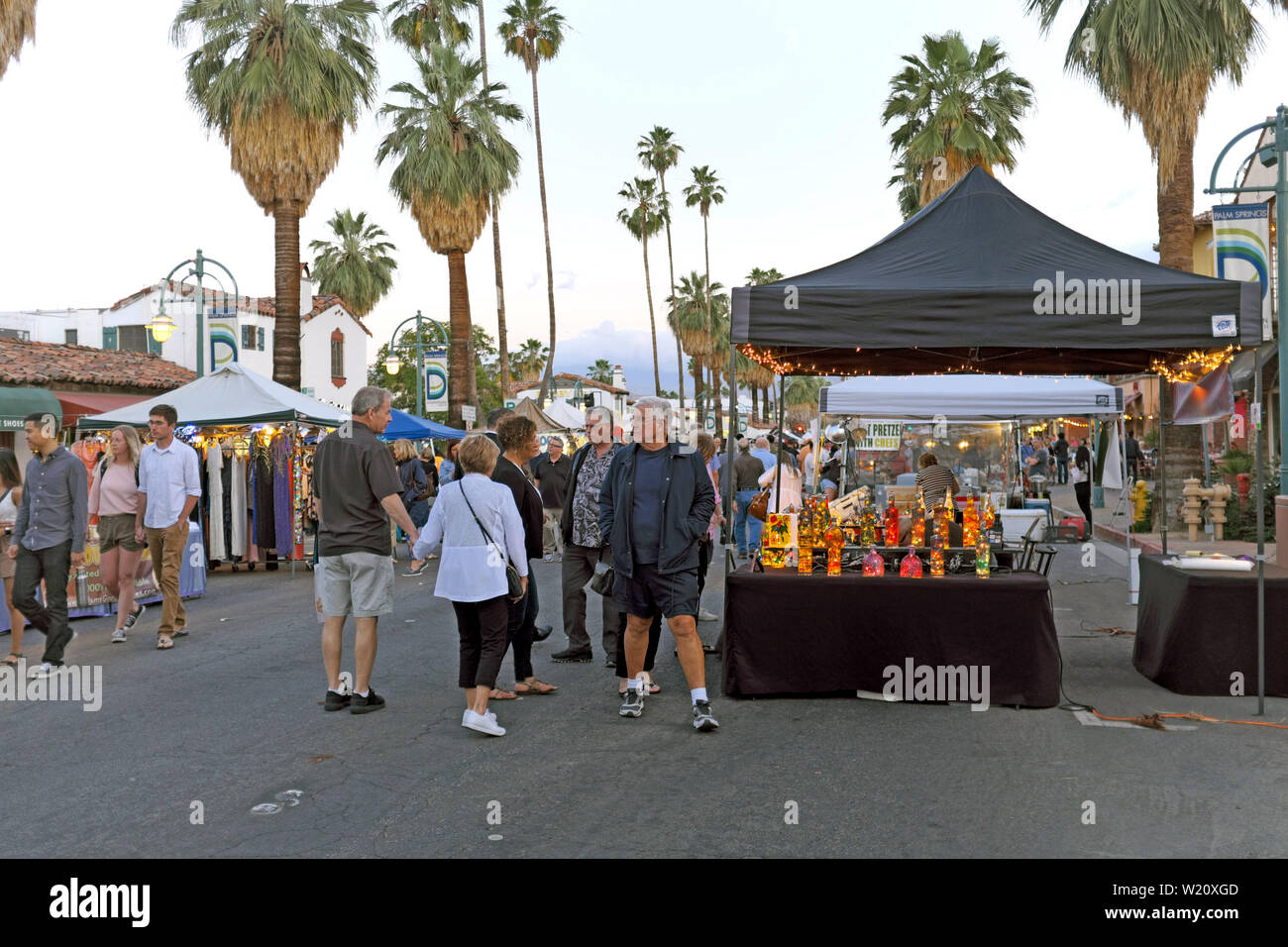 La gente disfruta del Villagefest en el centro de Palm Springs, California. La feria de jueves por la noche ofrece arte, artesanía, comida y entretenimiento. Foto de stock