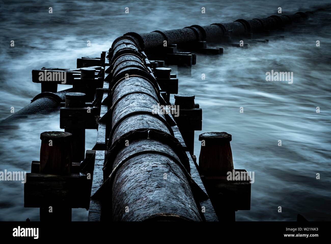 Tubo de hierro oxidadas, tubo de aguas residuales en el mar, surf, Blyth, Northumberland, Gran Bretaña Foto de stock