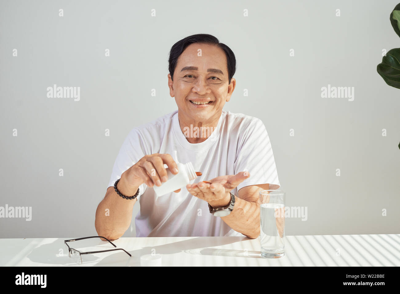 Retrato de ancianos hombre asiático tomando medicamento cada día Foto de stock