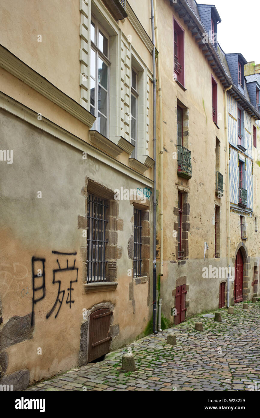 Una angosta calle adoquinada con edificios antiguos en Rennes, la capital de Bretaña, Francia Foto de stock