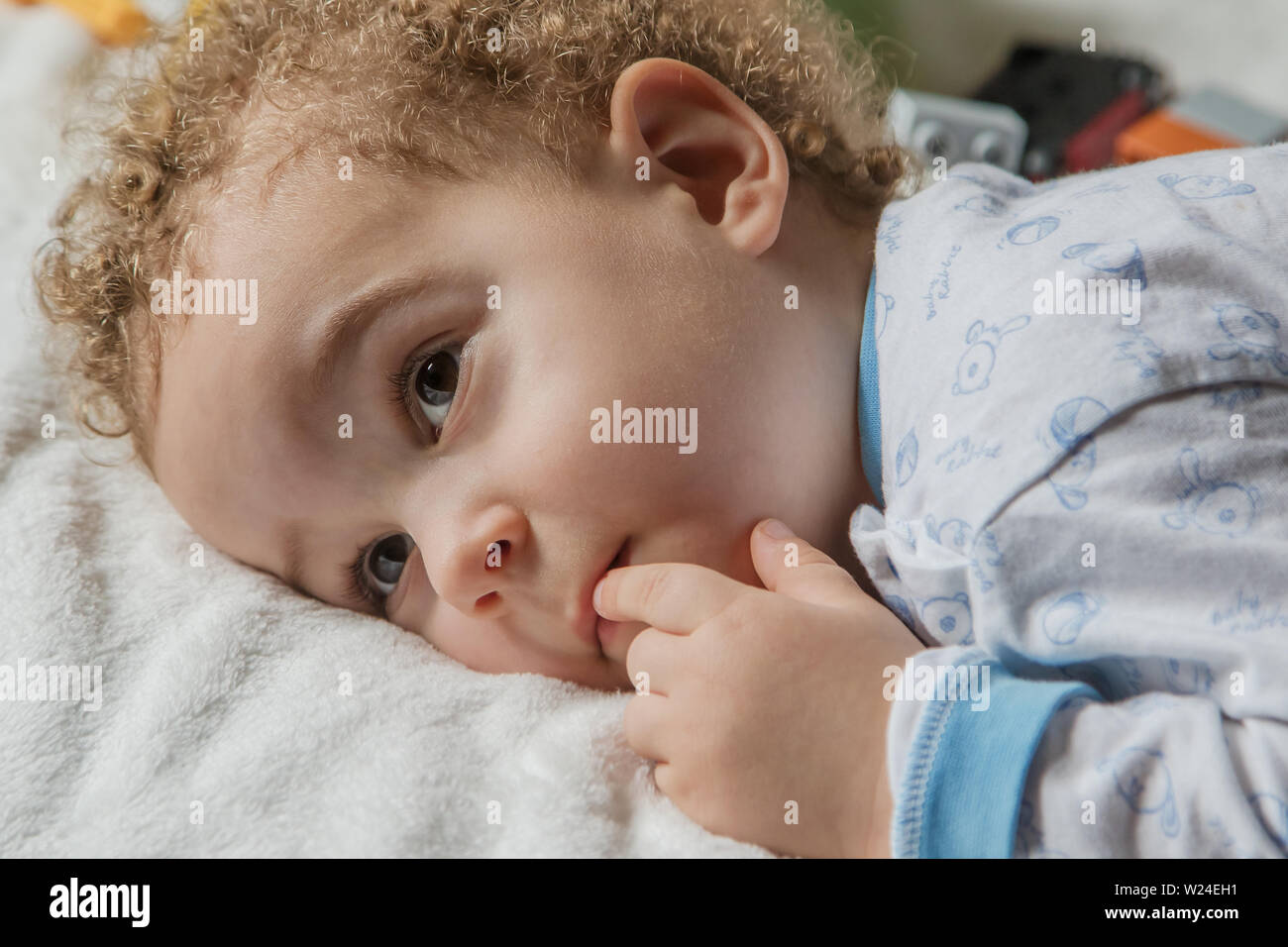 Adorable dos años cabrito en pijama suave con colores azul y cone en la soleada habitación de los niños. El sueño del niño concepto, enfoque suave. Foto de stock