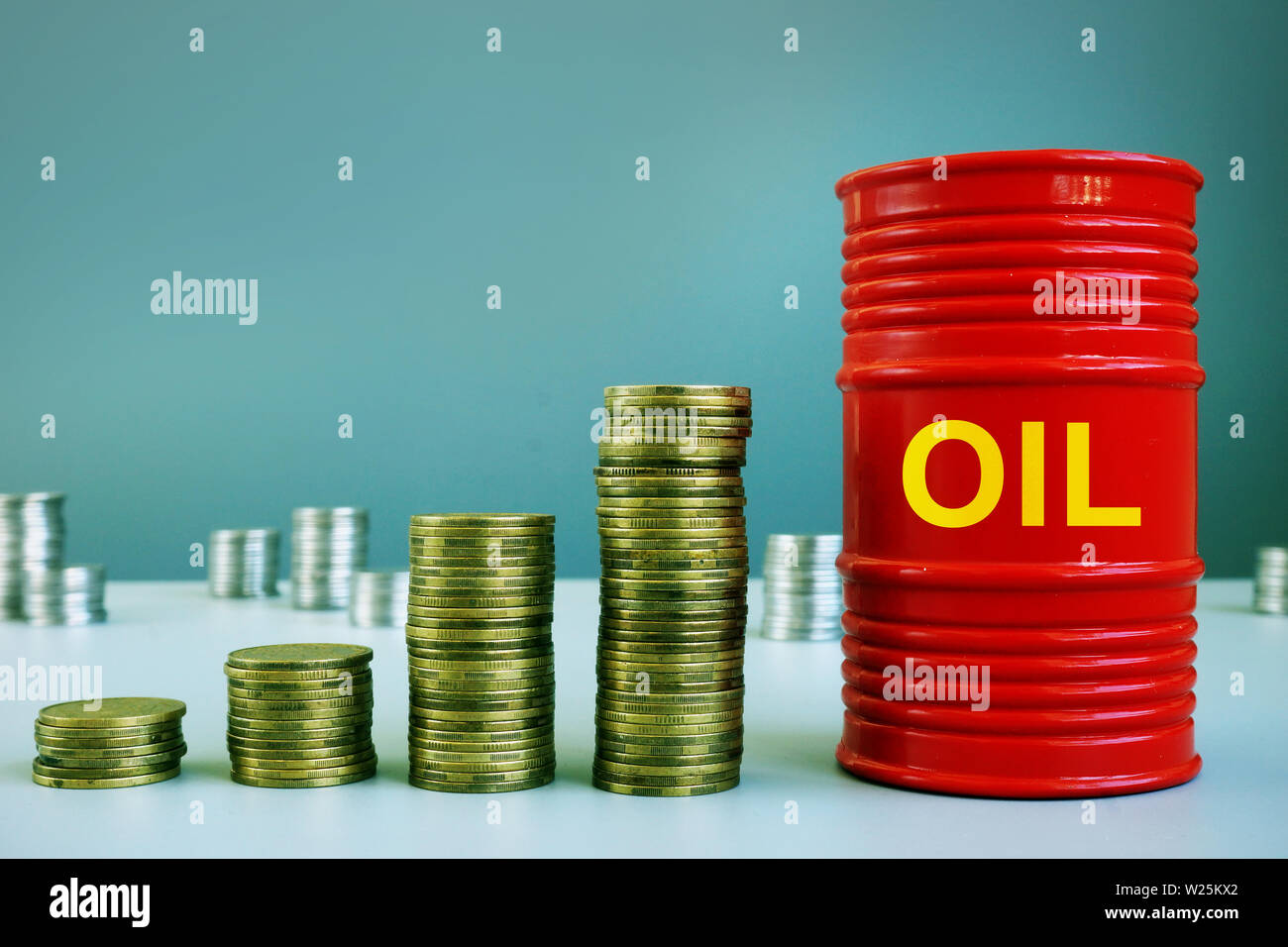 Concepto de subida de los precios del petróleo. Pila de monedas y de barril. Foto de stock