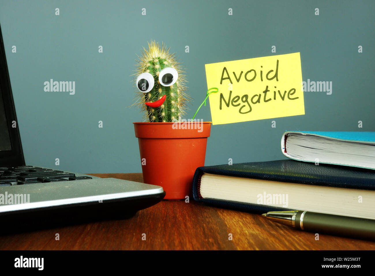 Evitar los negativos. Cactus sonrientes en el escritorio. Pensamiento positivo. Foto de stock