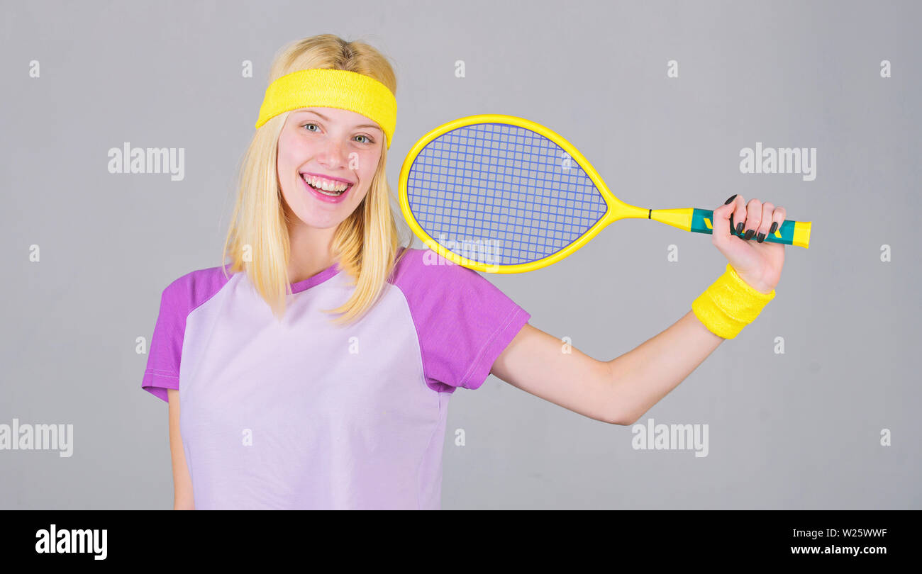 Club de Tenis concepto. Adorable rubia chica jugar al tenis. El deporte para mantener la salud. Ocio activo y hobby. Atleta mantenga raqueta de tenis en la mano sobre un fondo gris. Tenis deporte y entretenimiento. Foto de stock