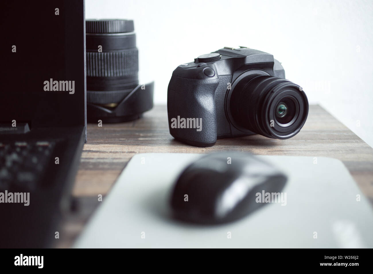 Fotógrafo o concepto de fotografía de stock, digital cámara negra cerca de la estación de trabajo portátil en el escritorio Foto de stock