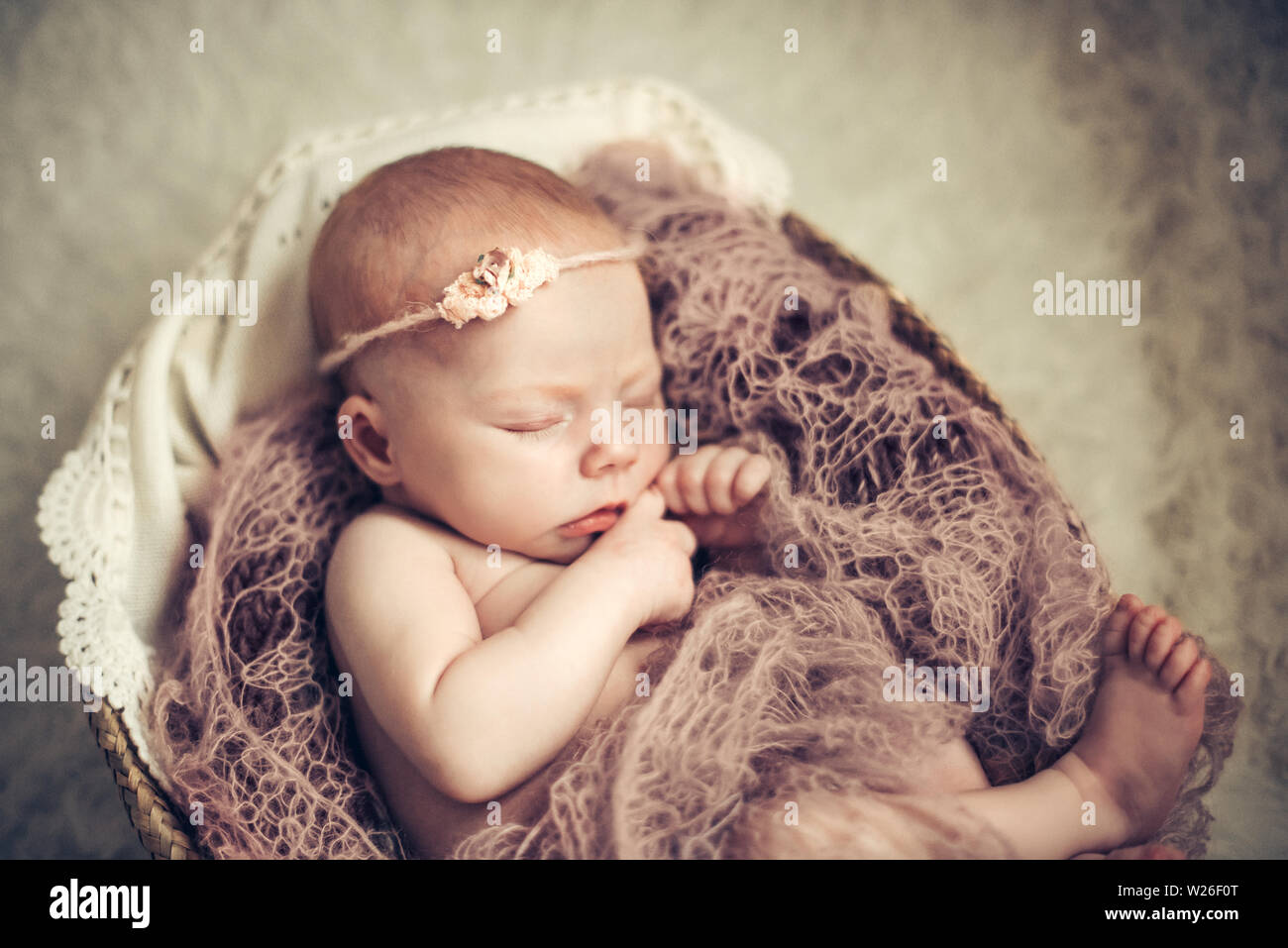 Bebé niña durmiendo en una cesta. Concepto de disparo, la inocencia de los recién nacidos. Foto de stock